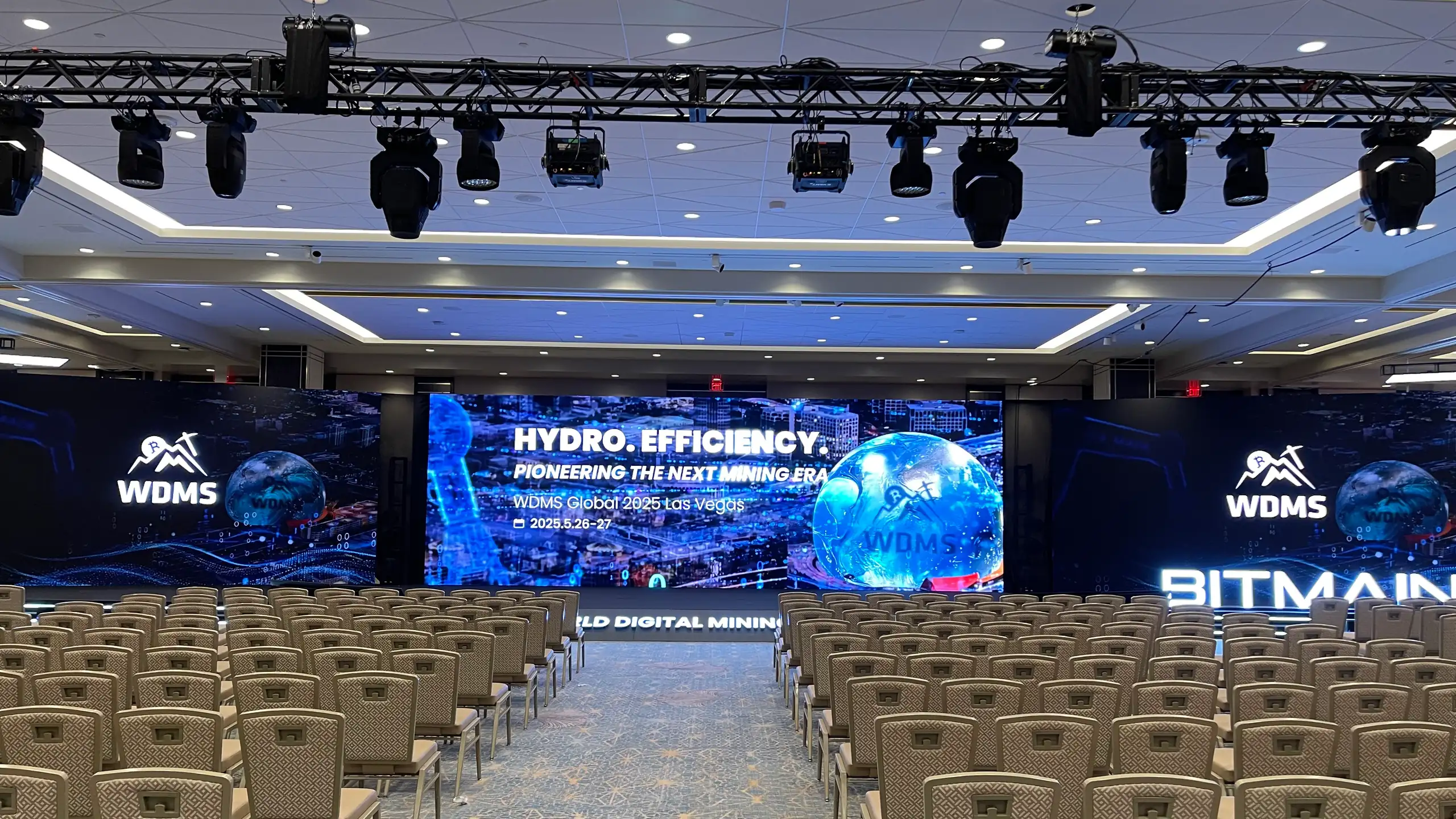 Three LED screens across the stage of the WDMS Global 2025 ballroom at Resorts World Las Vegas, before the doors opened