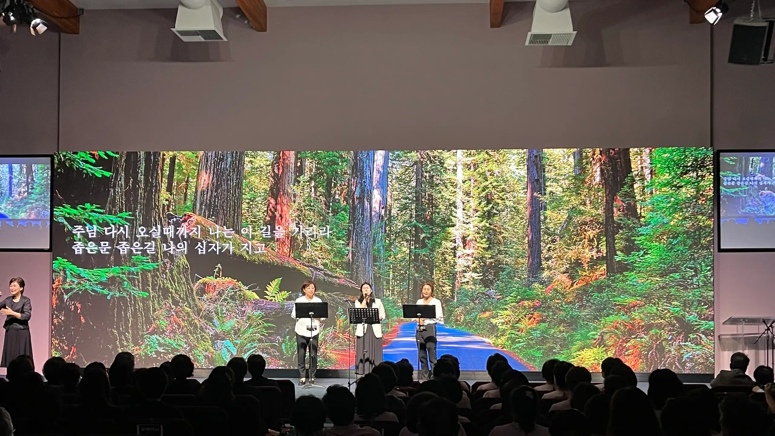 Worship at Good Stewards Church, West Covina, in front of a stage-wide LED wall showing a redwood forest