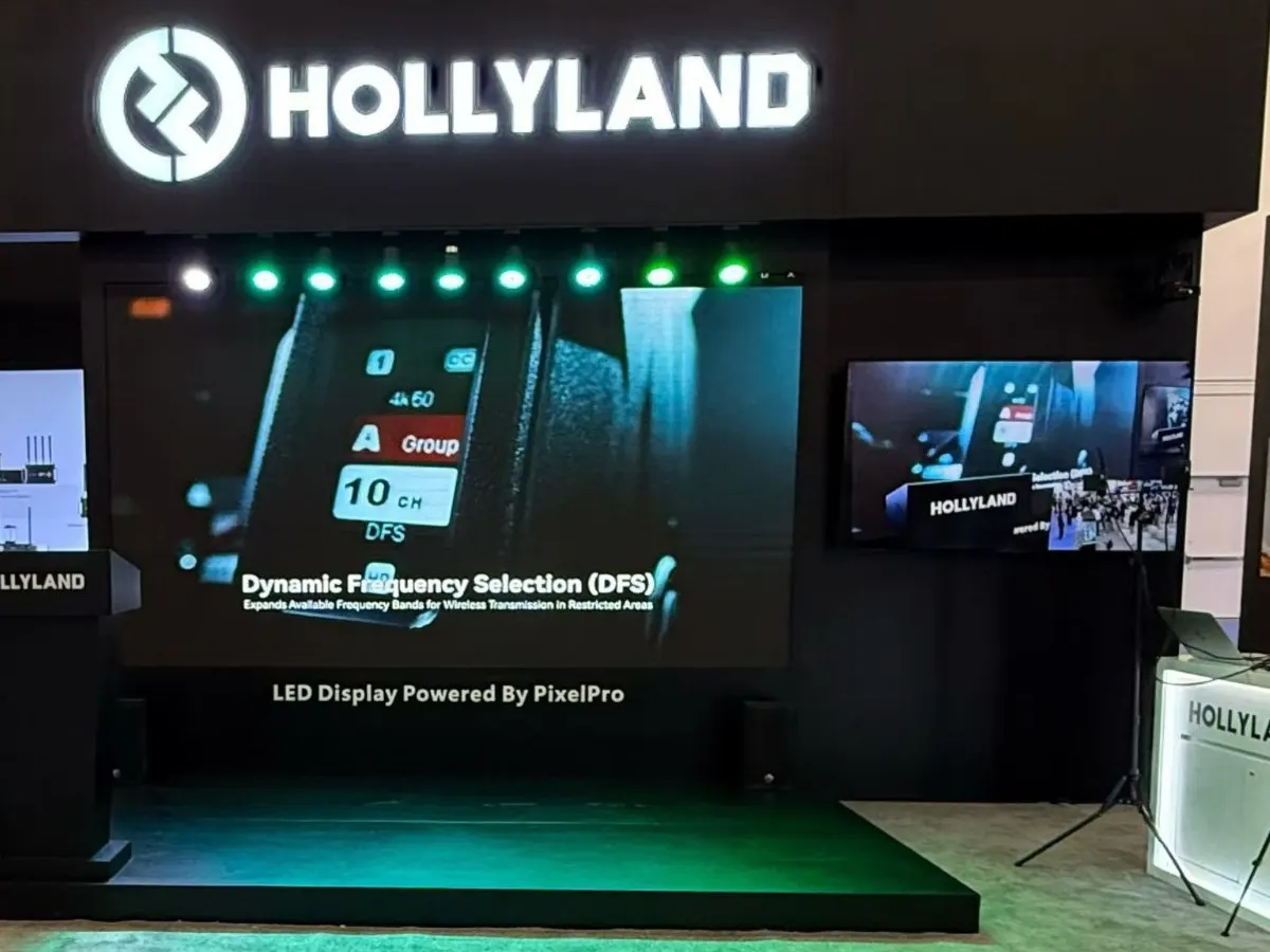 Behind the booth’s presentation stage. The line under the wall reads “LED Display Powered By PixelPro”.