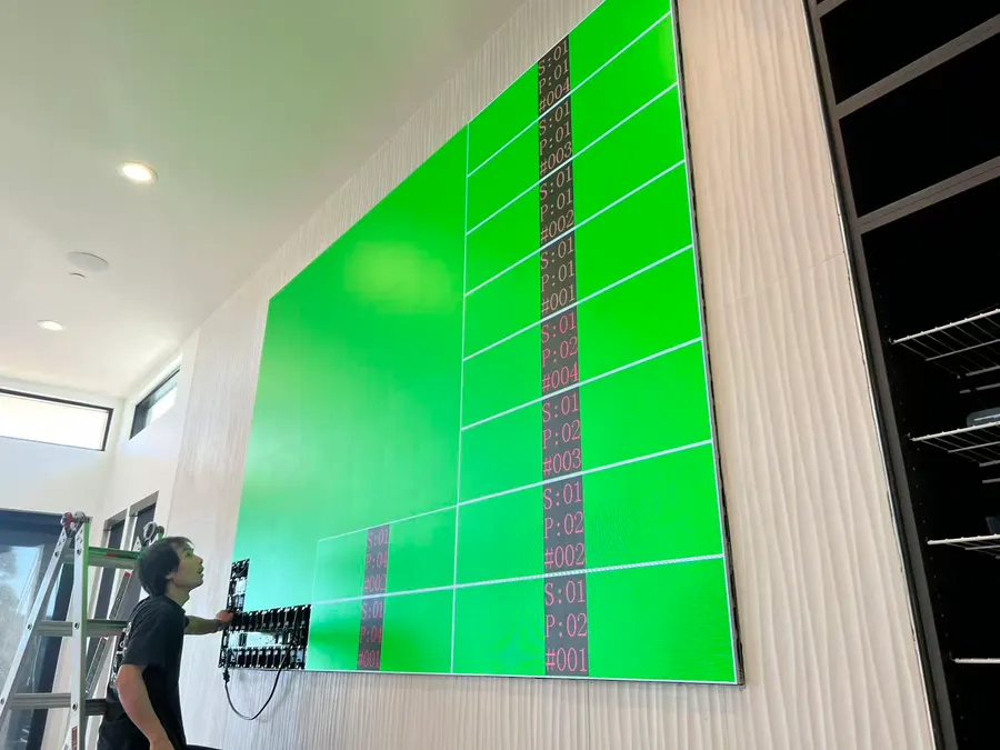 A person beside it shows the size: the 142-inch wall on its test pattern